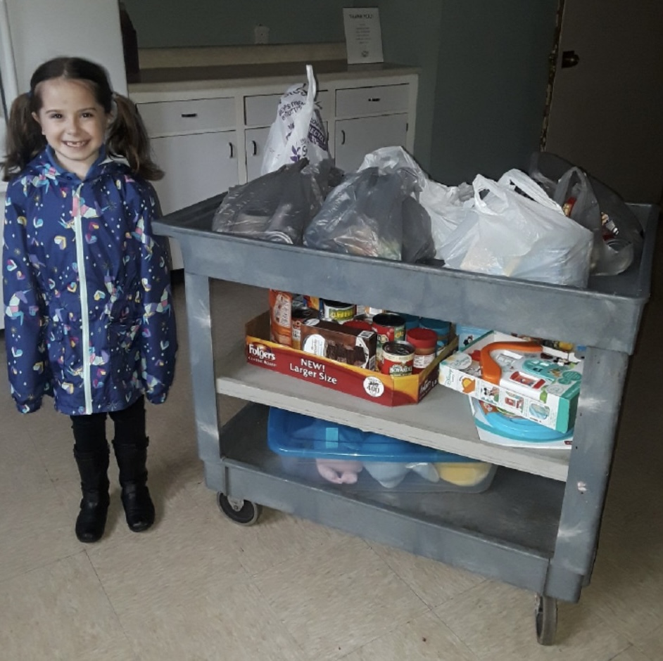 girl standing next to a cart of food